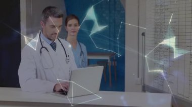 Hemşire hasta dosyalarına katılıp altını çizerken doktor klinik masasında dizüstü bilgisayarı yazıyor. Tıbbi, profesyonel, takım çalışması, işbirliği, klinik, sağlık, belgeleme