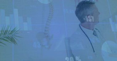 Doktor veri uyarısını fark ediyor ve tıbbi kayıtları inceliyor. Arkasında sırıtan çizelgeler var. Tıbbi, profesyonel, araştırmacı, analiz, sağlık, veri, çevre