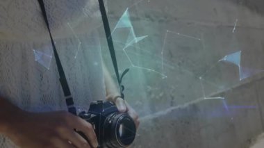 Fotoğrafçı odak halkasını ayarlıyor düğmeye basıyor ve dijital küre oluşturan çokgenler üretiyor. Gelecek, teknoloji, yenilik, dijital, hologram, kentsel, yaratıcı