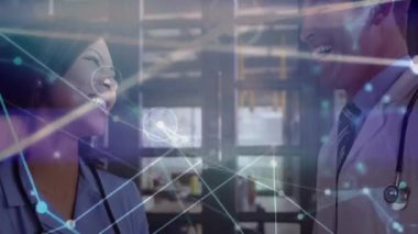 Hemşire ve doktor, klinikte başlarını sallayarak steteskopların etrafında dijital örgü örüyorlar. Sağlık, işbirliği, teknoloji, yenilik, profesyonellik, dijital, iletişim