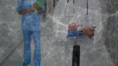 Doktor ve hemşire hasta dosyalarını kontrol ederken ağ örtüsü hastane koridorunda kayboluyor. Sağlık personeli, sağlık hizmetleri, işbirliği, klinik, tanı, mesleki, güvenlik