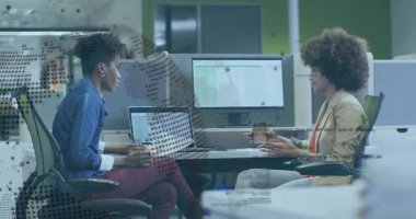 Laptop ekranında iş tablosunu gözden geçiren bir kadın kahve fincanını meslektaşına veriyor. İşbirliği, takım çalışması, ofis, profesyonel, üretkenlik, modern, iletişim