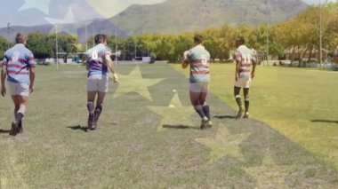 Çizgili formalı oyuncular topla oynamak için eğildiler ve ragbi sahasında kameraya doğru pas verdiler. Sporcular, takım çalışması, antrenman, atletizm, açık hava, rekabetçi, spor giyim