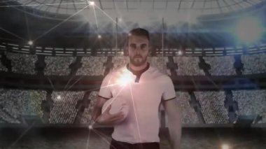 Kamera, spor sahasında ragbi topu tutan bir sporcunun yörüngesinde parlayan çizgileri gösteriyor. Spor, atletizm, dijital, bağlantı, yenilik, kesinlik, rekabet