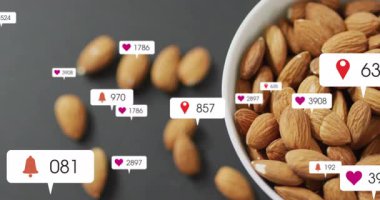 Badem üzerine lokasyon iğnesi fırlatılıyor, ikonlar büyüyor sonra fındık kasesinin üzerinde kayboluyor. Atıştırma, sağlık, canlılık, minimalizm, dijital, modern, besleyici