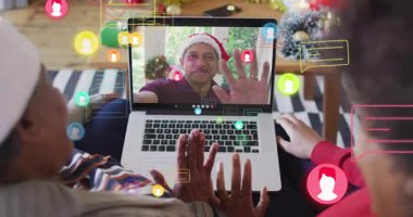 Kızı tıklaması ve annesinin bilgisayarla el sallaması sanal tatil selamlaması için sohbet baloncukları başlatıyor. Şenlikli, kutlama, bağlı, sıcak, teknoloji, aile bağı, samimi