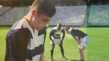 Rugby oyuncusu kafa kaldırıyor, nefes alıyor, çimen sahasındayken takım arkadaşlarını çağırıyor, bir sonraki oyun için toparlanıyor. Atletik, takım çalışması, kararlılık, açık hava, spor, güçlü, rekabetçi