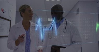 İki doktor kalp verilerini ECG dalgalı mavi pembeyle inceleyerek tablet yürüyorlar. Tıbbi, sağlık, teknoloji, yenilik, teşhis, prognoz, profesyonellik