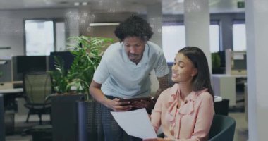 Tablet meslektaşı, dosya kaplamalı belge inceleme raporunu işaret ederek yaklaşıyor. İşbirliği, takım çalışması, iletişim, modern, profesyonel, tartışma, çalışma alanı