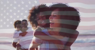 Bayrağın belirdiği, ailenin dalgaların arasında yürüdüğü, vatansever seyahat pazarlamasının gösterildiği bir yer. Aile, sahil, kutlama, açık hava, eğlence, neşe, kaynaşma