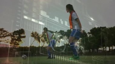 Yeşil yelekli saldırgan analitik günbatımı perdesiyle düşmek için top sürüyor ve savunma numarası yapıyor. Spor, takım çalışması, antrenman, atletik, performans, açık hava, yarışma