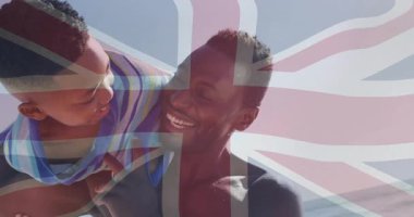 Babası su kenarına yakın eğilmiş beşikte, oğlu ise deniz kıyısındaki sağlık kaynaşması için yukarı doğru sallanıyor. Aile, açık hava, eğlence, bağlantı, eğlenceli, giysi, doğal