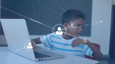 Çocuk bilgisayarda hareket ediyor ve verileri yazarken teknoloji ağı simgelerini etkinleştiriyor. Teknoloji, iletişim, yenilik, dijital, bağlantı, eğitim, çalışma alanı