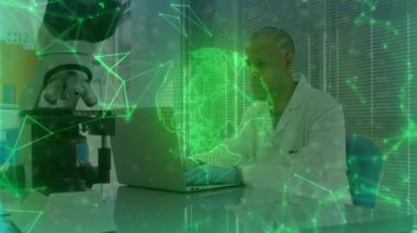 Diz üstü bilgisayarda yazan araştırmacı, yeşil hologram küre döndürme ve veri akışı analizi yapıyor. Bilim, teknoloji, yenilik, veri, dijital, modern, profesyonel