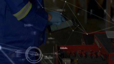 Bakım teknisyeni, atölyedeki kırmızı sepetten tableti kaldırıyor. Teşhis verileri üst üste geliyor. Sanayi, teknoloji, güvenlik, otomasyon, mühendislik, analitik, işbirliği