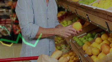 Midage erkek alışverişçi alışveriş arabalarını market koridorunda itiyor, portakal seçiyor, satın almak için fiyat grafiklerini analiz ediyor. Sağlık, sağlık, alışveriş, tazelik, beslenme, tüketici, veri