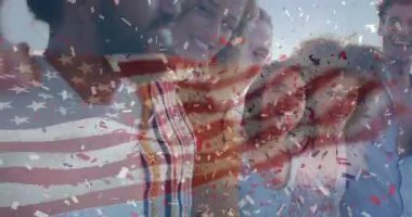 Dostlar bayrak kaplamasına tepki veriyor ve izleyiciye doğru dönüyor, pazarlama için konfetiyle birleştiriyorlar. Kutlama, birlik, yoldaşlık, vatanseverlik, açık hava, şenlik, toplum