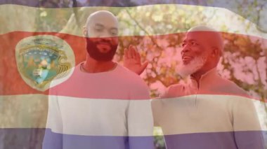 Baba oğlunun omzuna elini koyuyor sonbahar yürüyüşü sırasında cesaret verici tavsiyeler veriyor. Nesiller boyu, akıl hocalığı, arkadaşlık, açık hava, dingin, içten, bağ kurma