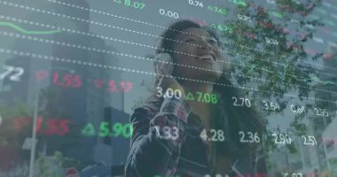 Sokakta kulaklık kullanan, şeffaf finans şemasını çalıştıran ve piyasa güncellemesinde gülümseyen bir kadın. Kentsel, teknoloji, finans, yaşam tarzı, modern, eğlence, gelişigüzel