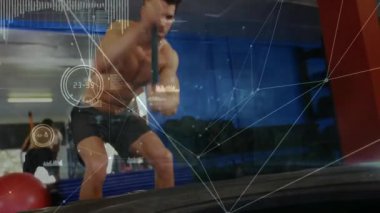 Adamın biri jimnastik salonunda balyoz kaldırıyor ve lastik eziyor dijital izleme matkabının yoğunluğunu örtüyor. Güç, zindelik, antrenman, egzersiz, hareket, kararlılık, dayanıklılık