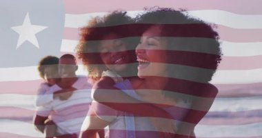 Pazarlamacı anne, bayrak altında kızını sırtında taşıyor. Kollarını açıp, babasını yanında taşımaya davet ediyor. Aile, birliktelik, açık hava, sahil, sıcaklık, canlılık, bağlantı