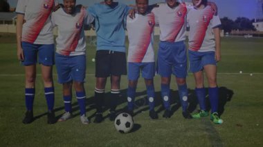 Dijital grafikler canlandırılırken altı bayan futbolcu sahada poz veriyor. Atletik, takım çalışması, yoldaşlık, yenilik, açık hava, dinamik, kapsayıcılık