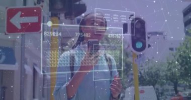 Sokakta akıllı telefonu tutan adam ararken teknoloji verilerini üst üste koyuyor, aracı selamlıyor. Gelecekçi, kentsel, dijital, yenilik, bağlantı, teknoloji, akıllı şehir