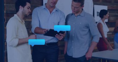 Üç erkek iş arkadaşı, sohbet baloncukları üzerine tablet okutarak iş brifinginde rehberlik ediyor. İşbirliği, takım çalışması, iletişim, dijital, modern, işyeri, sosyal