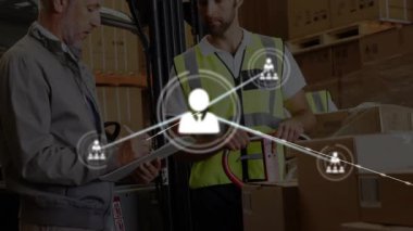 Kutuları işaret eden ve panoları kontrol eden iki iş arkadaşı envanter için büyüyen ağ simgelerini başlatıyorlar. Endüstriyel, takım çalışması, lojistik, bağlantı, verimlilik, operasyonel, modern