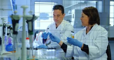 Analiz için örnek sunan kadın bilimadamı erkek bilim adamı olarak tüplere çizelge yerleştiriyor. Araştırma, kesinlik, yenilik, işbirliği, analitik, deney, laboratuvar