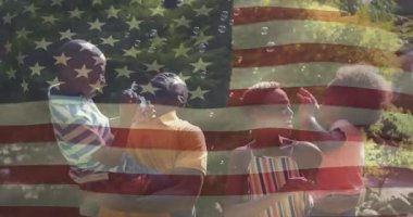 Ebeveynler çocuklara asa verdikten sonra, çocuklar pazarlama için bayrak altında sabun köpükleri üflüyorlar. Aile, açık hava, kutlama, neşeli, neşeli, boş zaman, huzur