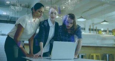 Üç kişilik ekip dizüstü bilgisayarın üzerine eğilip çizelgeyi tartışırken yüzen analitik simgeleri güncelliyor. İşbirliği, takım çalışması, veri analizi, yenilik, dijital pazarlama, modern ofis, üretkenlik