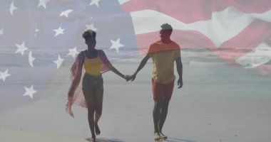 Kıyı şeridi boyunca el ele tutuşan çift, seyahat reklamında dalgalanan dalgalar halinde kareye giriyor. Romantik, deniz kenarı, açık hava, gündelik, boş zaman, dinginlik, bağlantı