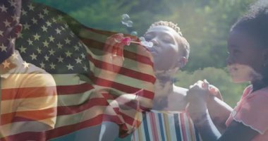 Aile bahçede pembe asaları ayarlıyor, sabun köpükleri üflüyor, eğlence için şeffaf bayrak örtüsü gösteriyor. Eğlence, eğlence, açık hava, eğlenceli, kutlama, canlı, rahat giysi