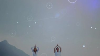 Çemberler sürükleniyor yoga ikilisi ilham veriyor. Kumsalda dengede duran eller hafif kavisler altında. Spiritüellik, farkındalık, dinginlik, meditasyon, uyum, refah, ruhani