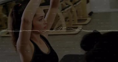 Ekran dışı eğitmen, yoga alıştırması için kalp şekilleri oluşturan paspaslar üzerindeki kadınlara rehberlik ediyor. Fitness, yoga, sağlık, grup egzersizi, farkındalık, esneklik, uyum