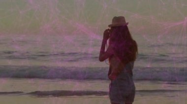 Kamerayı kaldıran kadın fotoğraf çekmek için okyanus ufkunu yakalar ve kaldırır. Manzara, sükunet, açık hava, doğal, rahatlama, minimalist, kompozisyon