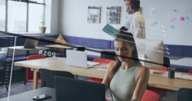 Analizde dizüstü bilgisayarı yazan stajyer, veri satırlarını ve yıllarını kaplayan klasörü inceleyen ekip. İşbirliği, takım çalışması, yenilik, teknoloji, profesyonel, çalışma alanı, beyin fırtınası