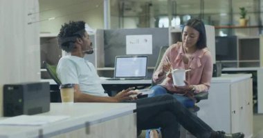 Kadın çubukla şehriye yerken adam arkasını yaslanıp iş konuşmaya başlıyor. İşbirliği, tartışma, gündelik, modern, çalışma alanı, takım çalışması, dinleyici