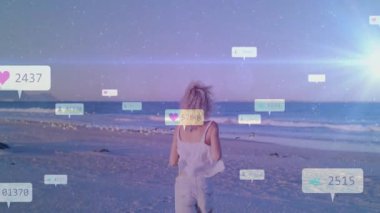 Alacakaranlık kumsalında koşan bir kadın sosyal medyanın artan nişanını gösteren sosyal ikonlar üretiyor. Dijital, canlılık, açık hava, estetik, fitness, bağlantı, enerjik