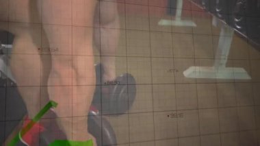 Dambıl tutan erkek kaldırıcı spor salonunda canlı grafiklerle ilerlemeyi takip ederken bençe basıyor. Fitness, dayanıklılık, egzersiz, dayanıklılık eğitimi, spor aletleri, atletizm