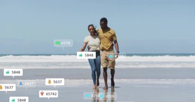 Sahilde yürüyen bir çift sosyal medya animasyonlarını aktifleştiriyor ve çevrelerinde bağlılık artışı gösteriyor. Romantizm, bağlantı, dinginlik, dijital, teknoloji, rahatlık, ifade