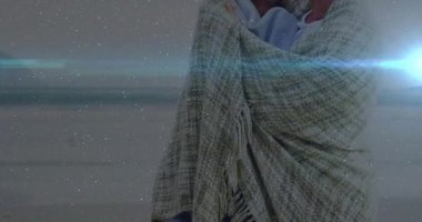 Çift, sevgi dolu bakışlarını paylaşmak için alacakaranlık kumsalında battaniyeyi sarıyorlar. Romantik, samimiyet, şefkat, günbatımı, sahil, konforlu, bağlantı