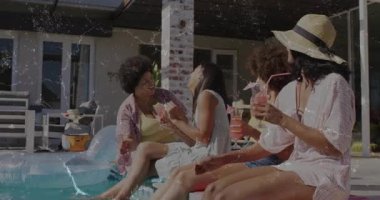 Şapkalı kadın havuz kenarında fazladan kokteyl kaldırıyor, dört arkadaş pembe içkilerini yudumluyor ve yaşam tarzına kadeh kaldırıyor. Boş zaman, kutlama, açık hava, lüks, güneş ışığı, dostluk, canlılık.