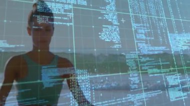 Sahilde nefes alan bayan sporcu, dijital ızgarayı etkinleştiriyor ve iyileşmek için verileri birleştiriyor. Fitness, farkındalık, teknoloji, sükunet, dinginlik, yenilik, uyum