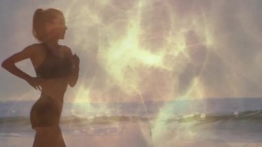 Soyut altın ışık kıyı şeridini kaplıyor, fitness koşucusu gün doğumunu selamlıyor. Gün doğumu, fitness, hareket, şafak, canlılık, kıyı, soyut