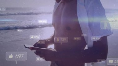 Sahilde akıllı telefonları kaydıran orta yaşlı bir adam sosyal medya baloncukları üretiyor ve nişanı yükseltiyor. Teknoloji, bağlantı, yaşam tarzı, rahatlama, modern, açık hava, boş zaman