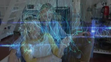 Koltukta oturan çift, dönen mavi enerji alanını fark ediyor ve teknolojiye doğru hareket ediyorlar. Gelecek, etkileşim, samimiyet, ortam, modern, bağlantı, merak