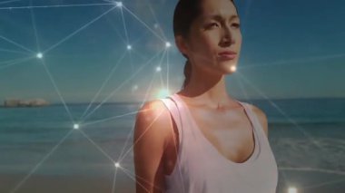 Sahile bakan bir kadın parlayan ağ örerek gövdeyi sararak teknolojik bağlantıyı kuruyor. Gelecek, bağlantı, yenilik, dinginlik, dijital alarm, minimalizm, zarafet