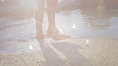 Teknik ağ simgeleri, insan kaymasını ve kullanıcıları bağlayan suya adım atmayı başlatan ayaklarda kayboluyor. Dijital, bağlantı, manzara, teknoloji, açık hava, fütüristik, sosyal